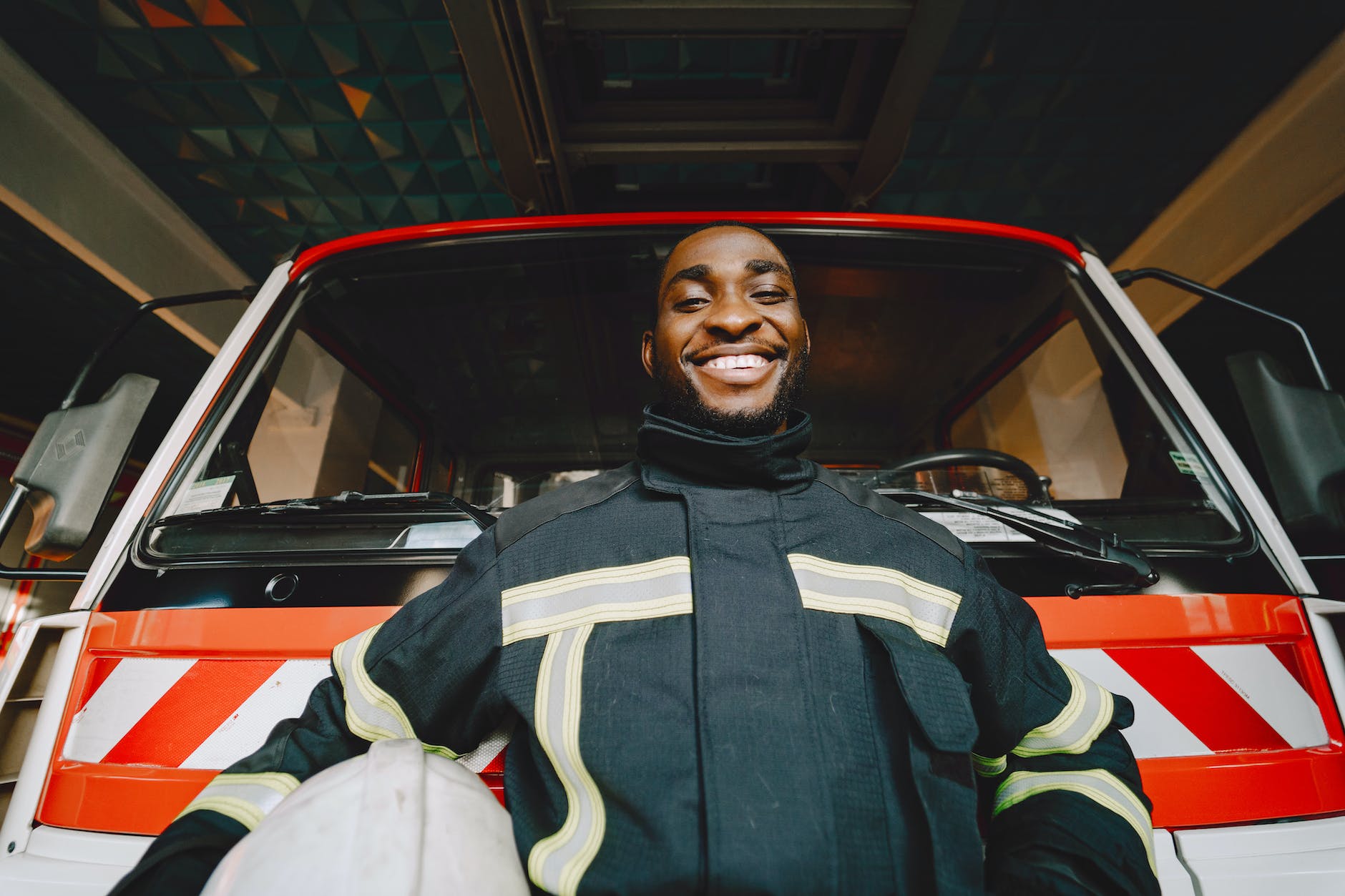 a man standing near fire truck smiling at the camera